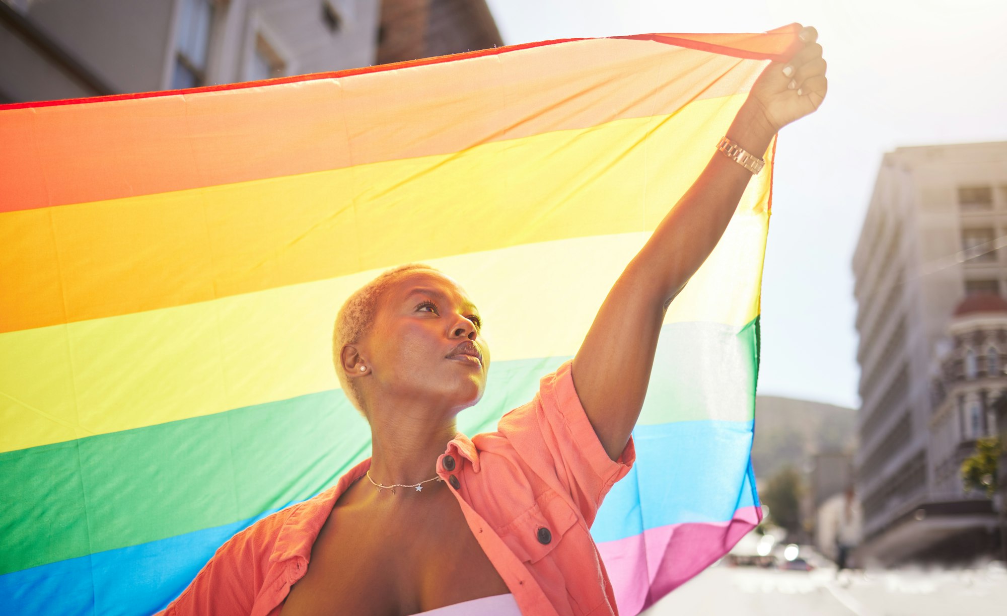 Lesbian, pride and black woman in city with flag for lgbtq community, ally or gay with support and